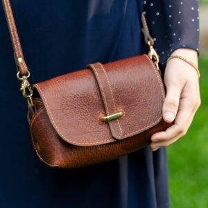 Woman in blue dress wearing the Mini Leather Crossbody Bag