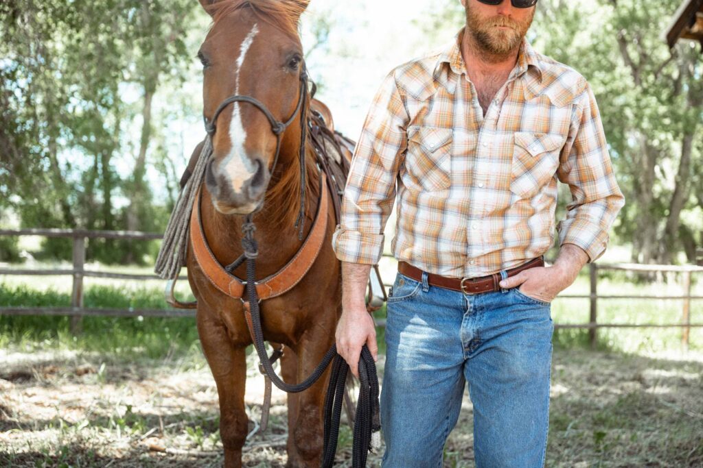 Man Wearing A Bison Leather Belt On Ranch While Walking A Horse Man Wearing A Bison Leather Belt On Ranch While Walking A Horse